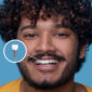young man with toothy smile demonstrating his dental implant 85x85